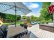 Wide shot of a patio area on an elevated deck with an umbrella over an outdoor table and cushioned chairs at 10717 Windermere Blvd, Fishers, IN 46037