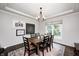 Inviting dining room featuring a rustic wooden table, black chairs, decorative chandelier, and stylish rug at 10717 Windermere Blvd, Fishers, IN 46037
