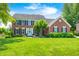 Charming two-story brick home with a well-manicured lawn and traditional architectural details at 10717 Windermere Blvd, Fishers, IN 46037