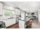Bright kitchen with white cabinets, stainless appliances, a large island, and hardwood floors overlooking the living area at 10717 Windermere Blvd, Fishers, IN 46037