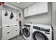This laundry room features modern washer and dryer units, with matching cabinets and a decorative tile floor at 10717 Windermere Blvd, Fishers, IN 46037