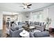 Open-concept living room with hardwood floors and comfortable sofas, flowing into kitchen space at 10717 Windermere Blvd, Fishers, IN 46037