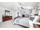 This main bedroom features a ceiling fan, dresser, and a door leading to the main bathroom at 10717 Windermere Blvd, Fishers, IN 46037