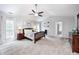 This main bedroom includes a ceiling fan, vaulted ceilings, bedside tables, and windows at 10717 Windermere Blvd, Fishers, IN 46037