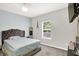Cozy bedroom with a tufted headboard bed, ceiling fan, and bright window at 10902 Jimmy Lake Dr, Indianapolis, IN 46239
