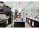 Open-concept kitchen featuring dark cabinets, stainless steel appliances, and a center island at 10902 Jimmy Lake Dr, Indianapolis, IN 46239