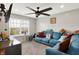 Upstairs living room with ceiling fan, large window, and comfortable blue seating at 10902 Jimmy Lake Dr, Indianapolis, IN 46239