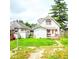 View of the home's backyard featuring a lawn and white wooden exterior with a small porch at 1115 N Kealing Ave, Indianapolis, IN 46201