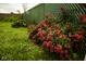 Lush backyard with a chain link fence covered in a rose bush and green grass at 1115 N Kealing Ave, Indianapolis, IN 46201