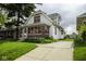 A view of the side and front of the house, showing the driveway and green lawn at 1115 N Kealing Ave, Indianapolis, IN 46201