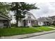 Exterior view showing home's front facade, green lawn, and adjacent houses on the street at 1115 N Kealing Ave, Indianapolis, IN 46201