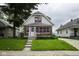 Charming home featuring a well-manicured lawn, brick accents, and a welcoming entrance at 1115 N Kealing Ave, Indianapolis, IN 46201