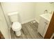Clean and functional powder room with toilet, vanity, and wood-style flooring at 1115 N Kealing Ave, Indianapolis, IN 46201