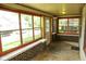 Enclosed sun porch with ample natural light, brick accents, and tiled floor at 1115 N Kealing Ave, Indianapolis, IN 46201