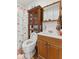 Bathroom featuring a vanity, mirror, toilet, and shower with vintage shelving at 1116 N Berwick Ave, Indianapolis, IN 46222