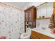 Modest bathroom featuring a vanity, mirror, toilet, and shower with patterned curtains at 1116 N Berwick Ave, Indianapolis, IN 46222
