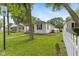 Landscaped side yard with a white picket fence surrounding a well-maintained lawn at 1116 N Berwick Ave, Indianapolis, IN 46222