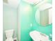 Powder room with a circular mirror and teal walls at 1139 Maple Stream Dr, Indianapolis, IN 46217