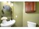 Powder room features a pedestal sink and a decorative mirror at 1143 Hampton Dr, Greenwood, IN 46143