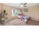 Cozy bedroom with a large window, white bookshelf, floral bedding, and a ceiling fan at 1143 Hampton Dr, Greenwood, IN 46143
