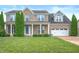 Elegant brick home with symmetrical design, blue shutters, and well-manicured lawn at 1143 Hampton Dr, Greenwood, IN 46143