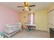 Pink and yellow bedroom with a crib, window and play area at 1159 Oak Leaf Rd, Franklin, IN 46131