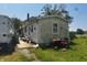 Exterior of a weathered one-story home with a chimney and overgrown grass, showcasing its potential for renovation at 1170 E 400 S, Lebanon, IN 46052