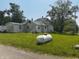 Exterior of a two-story house with visible propane tank in the front yard, surrounded by trees on a sunny day at 1170 E 400 S, Lebanon, IN 46052