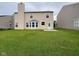 A spacious backyard featuring a well-maintained lawn, a small patio, and a view of the home's rear exterior at 12328 Quarry Face Ct, Fishers, IN 46037