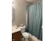 Bathroom featuring a vanity, toilet and shower-tub combo with blue-green shower curtain and tiled floor at 12328 Quarry Face Ct, Fishers, IN 46037