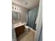 Bathroom featuring a vanity, toilet and shower-tub combo with blue-green shower curtain and tiled floor at 12328 Quarry Face Ct, Fishers, IN 46037