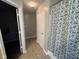 Bathroom featuring a shower-tub combo with floral shower curtain and open access to the toilet area at 12328 Quarry Face Ct, Fishers, IN 46037