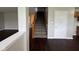 View of the hallway leading to the stairs in a home with hardwood floors, carpeted stairs and neutral walls at 12328 Quarry Face Ct, Fishers, IN 46037