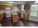 This kitchen features wood cabinets, white appliances, an island and a large window overlooking the yard at 12328 Quarry Face Ct, Fishers, IN 46037