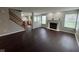 Open-concept living room with hardwood floors, fireplace, and stairway at 12328 Quarry Face Ct, Fishers, IN 46037