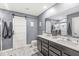 Modern bathroom features double sinks, barn door, and a large mirror, creating a spa-like experience at 126 Winding Brook Way, Pendleton, IN 46064