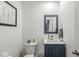 Clean half bathroom with dark blue cabinets, modern fixtures, and decorative accents at 126 Winding Brook Way, Pendleton, IN 46064