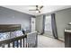 This cozy carpeted bedroom features a ceiling fan, a window with curtains, and dark grey walls at 126 Winding Brook Way, Pendleton, IN 46064