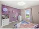 Carpeted bedroom with purple accent wall, white dresser, window, and colorful decor at 126 Winding Brook Way, Pendleton, IN 46064