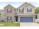 Two-story home featuring a two-car garage, brick accents, blue shutters, and a well-maintained lawn at 126 Winding Brook Way, Pendleton, IN 46064