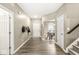 Hallway view features hardwood flooring, a white door, staircase with carpet, and a glimpse of the dining area at 126 Winding Brook Way, Pendleton, IN 46064