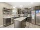 Well-lit kitchen featuring dark cabinets, quartz counters, stainless appliances, and open shelving at 126 Winding Brook Way, Pendleton, IN 46064