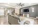 Cozy living room featuring grey sofas, a ceiling fan, a large TV, hardwood floors, and a staircase at 126 Winding Brook Way, Pendleton, IN 46064