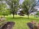 Beautiful backyard with lush green grass, mature trees, landscaped flower beds, and a manicured lawn at 12656 Cerromar Ct, Carmel, IN 46033