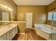 Bathroom with a garden tub, double vanity, and wood look flooring, offering a luxurious and functional space at 12656 Cerromar Ct, Carmel, IN 46033
