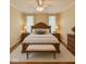 This bedroom features a wooden bed frame, ceiling fan, neutral colors, and wood nightstands with lamps at 12656 Cerromar Ct, Carmel, IN 46033