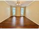 Spacious, empty room with hardwood floors, neutral walls, bright light from the windows, and a ceiling fan at 12656 Cerromar Ct, Carmel, IN 46033