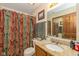 Bathroom with floral shower curtain, granite countertop, and ample vanity storage at 1547 Millridge Dr, Greenwood, IN 46143