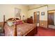 Bedroom featuring a red bedspread and wood paneled walls with view to attached bath at 1547 Millridge Dr, Greenwood, IN 46143