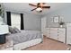 Light-filled bedroom with ceiling fan, light gray walls and a large dresser at 1744 Salina Dr, Avon, IN 46123